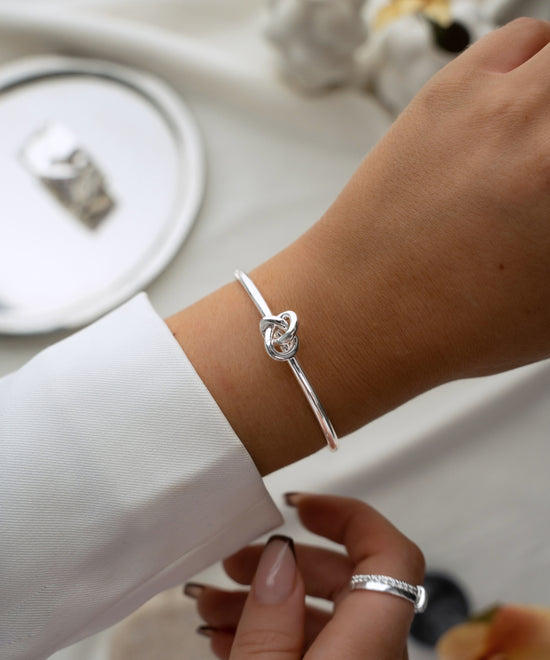 Avelore Veda Bangle in silver on a wrist with a white suit.