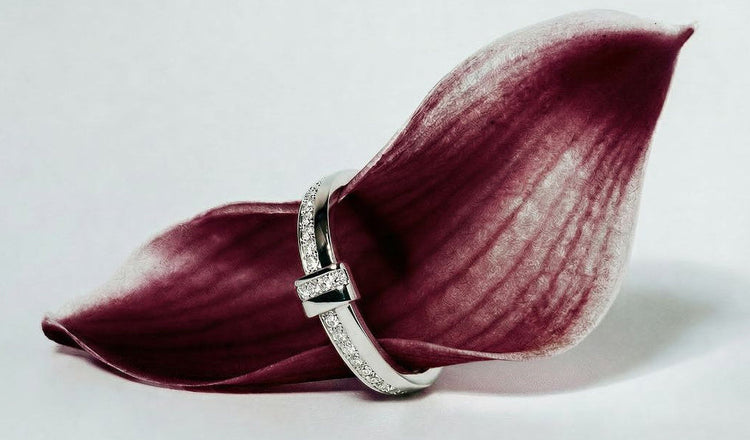 Avelore Diamond ring on a burgundy calla lily petal against a light gray background