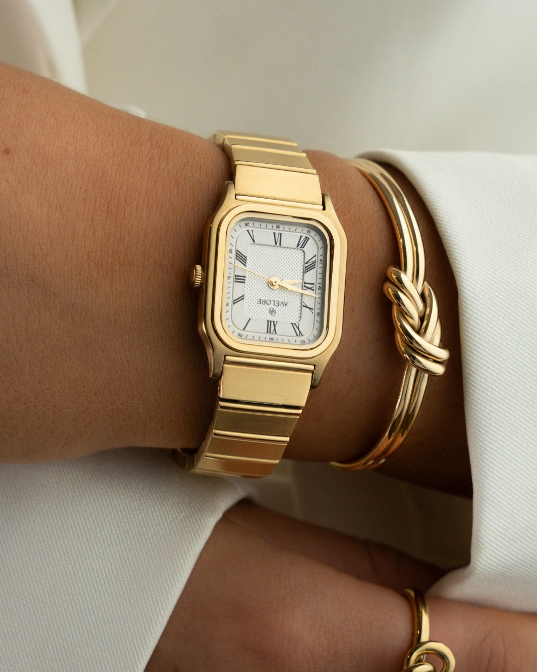 Gold square watch for women with white dial and gold band. The model is Aima by Avelore.