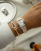 A gold and silver bracelet with loop knot detail. The model is Coce Bangle by Avelore Women's Bracelets.