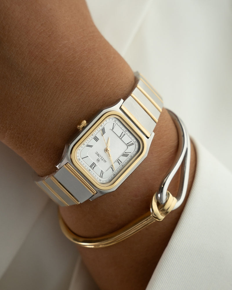 Two-tone square watch for women with silver dial and silver and gold band. The model is Aima by Avelore.