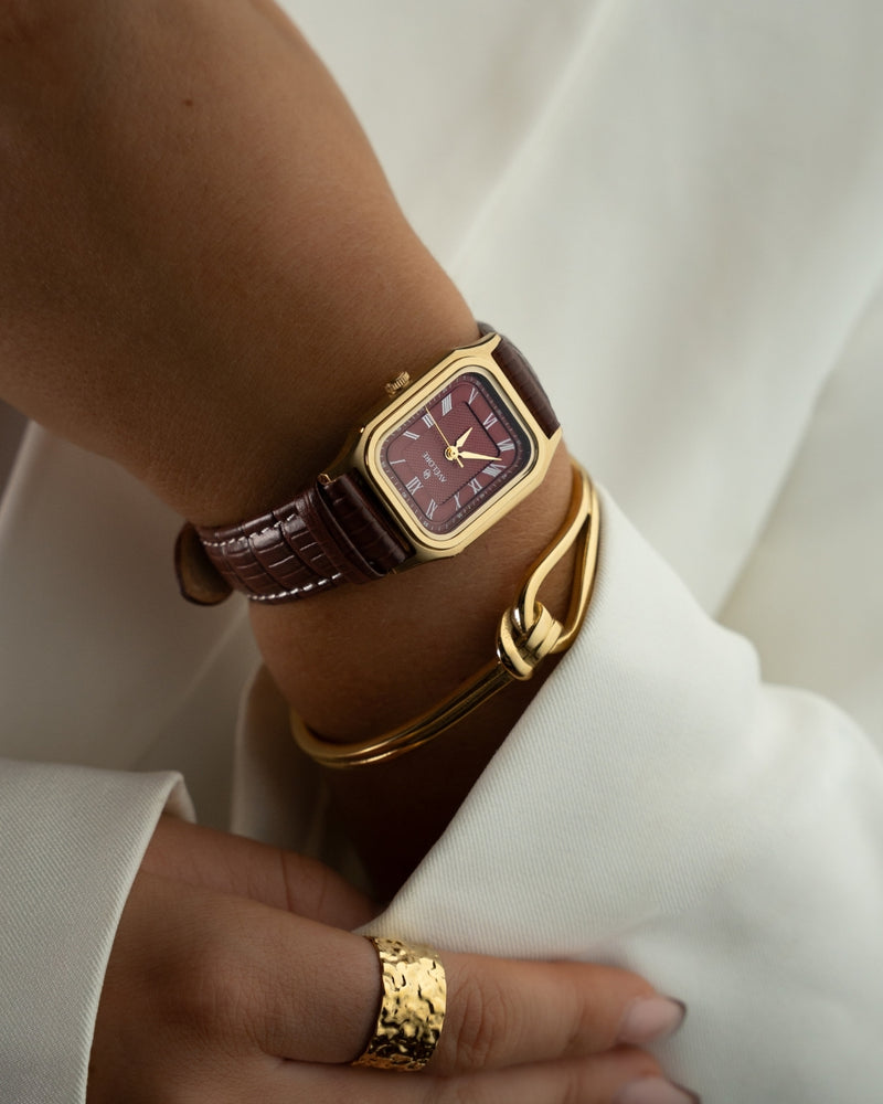 Gold square watch for women with burgundy dial and burgundy leather band. The model is Aima by Avelore.