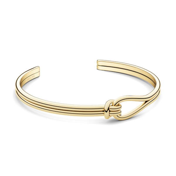 A gold bracelet with loop knot detail. The model is Coce Bangle by Avelore Women's Bracelets.