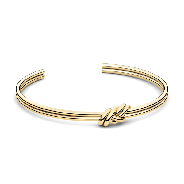 Gold bracelet with triple knot detail. The model is Naia bangle by Avelore Women's Bracelets