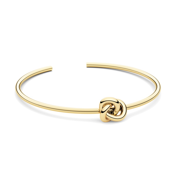Gold bracelet with a knot design. The model is Veda Bangle by Avelore. Women's Bracelets