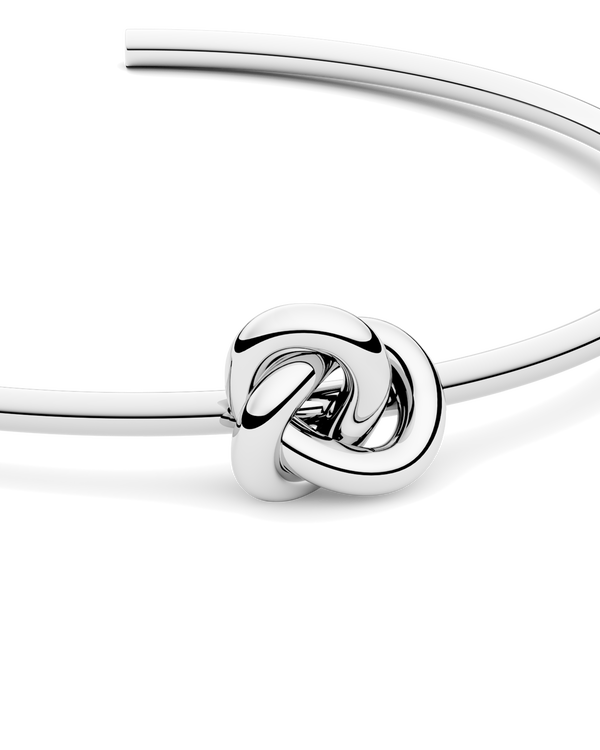 Silver bracelet with a knot design. The model is Veda Bangle by Avelore. Women's Bracelets