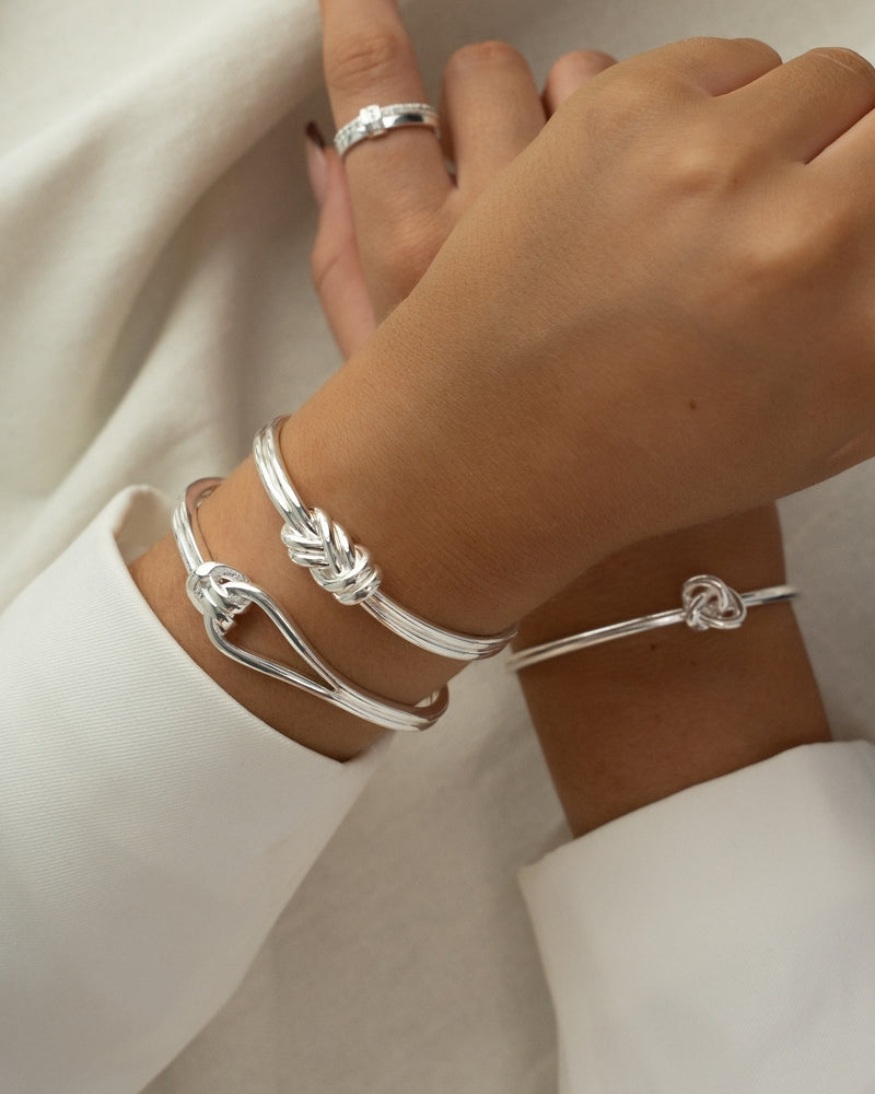 Silver bracelet with triple knot detail. The model is Naia bangle by Avelore Women's Bracelets
