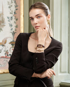 A gold bracelet with loop knot detail. The model is Coce Bangle by Avelore Women's Bracelets.