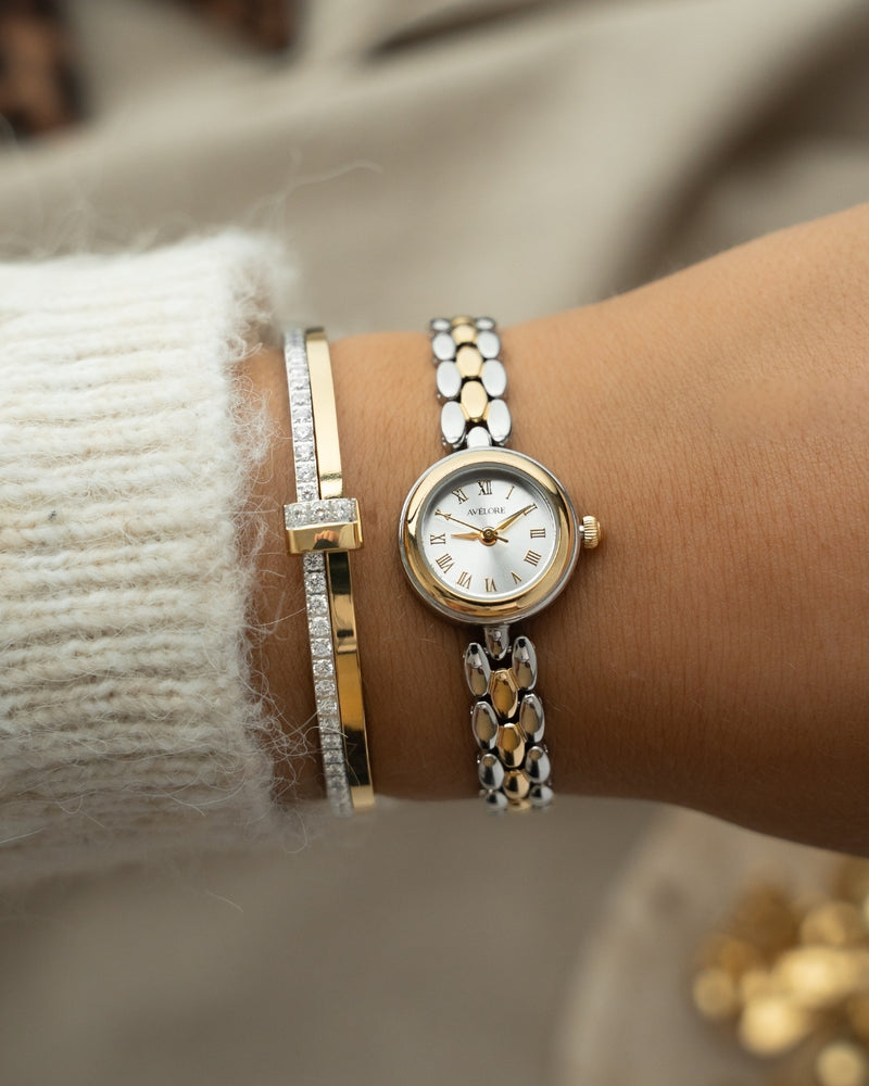 Two-tone round small watch for women with silver dial and silver and gold band. The model is Eira by Avelore.