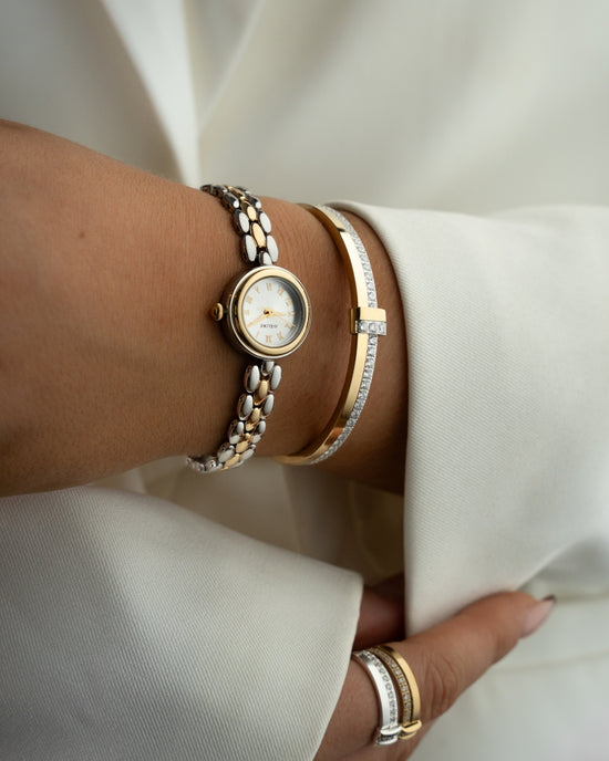 Two-tone round small watch for women with silver dial and silver and gold band. The model is Eira by Avelore.