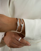 Silver bracelet with triple knot detail. The model is Naia bangle by Avelore Women's Bracelets