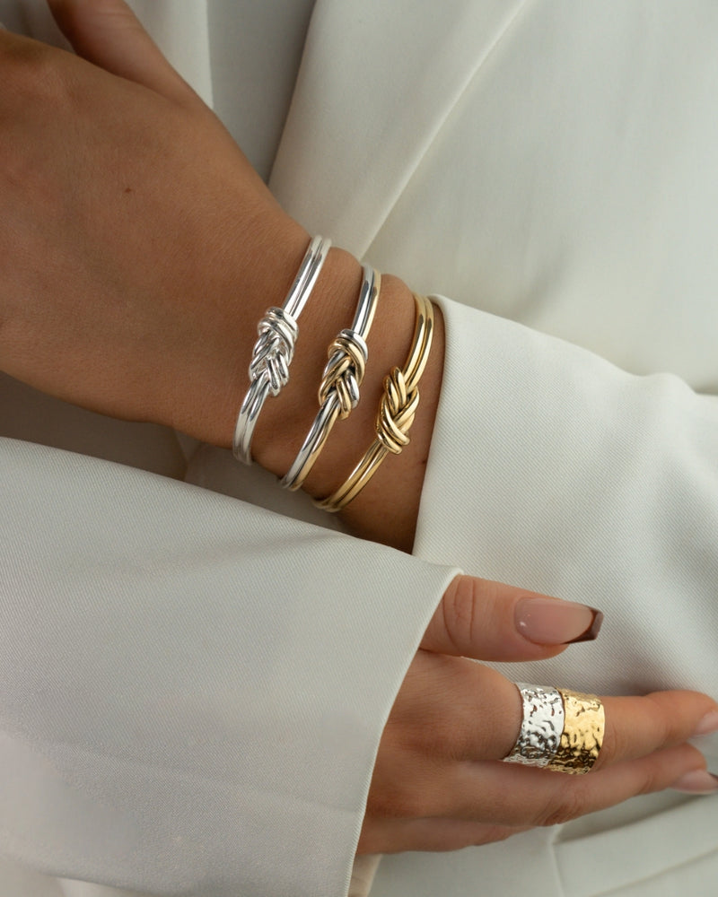 Two-toned bracelet with triple knot detail. The model is Naia bangle by Avelore Women's Bracelets