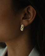 Two-toned earring with triple knot detail. The model is Naia earring by Avelore Women's Bracelets