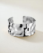 Wide Cuff Bracelet in silver with hammered surface. The model is Noem Bangle by Avelore.