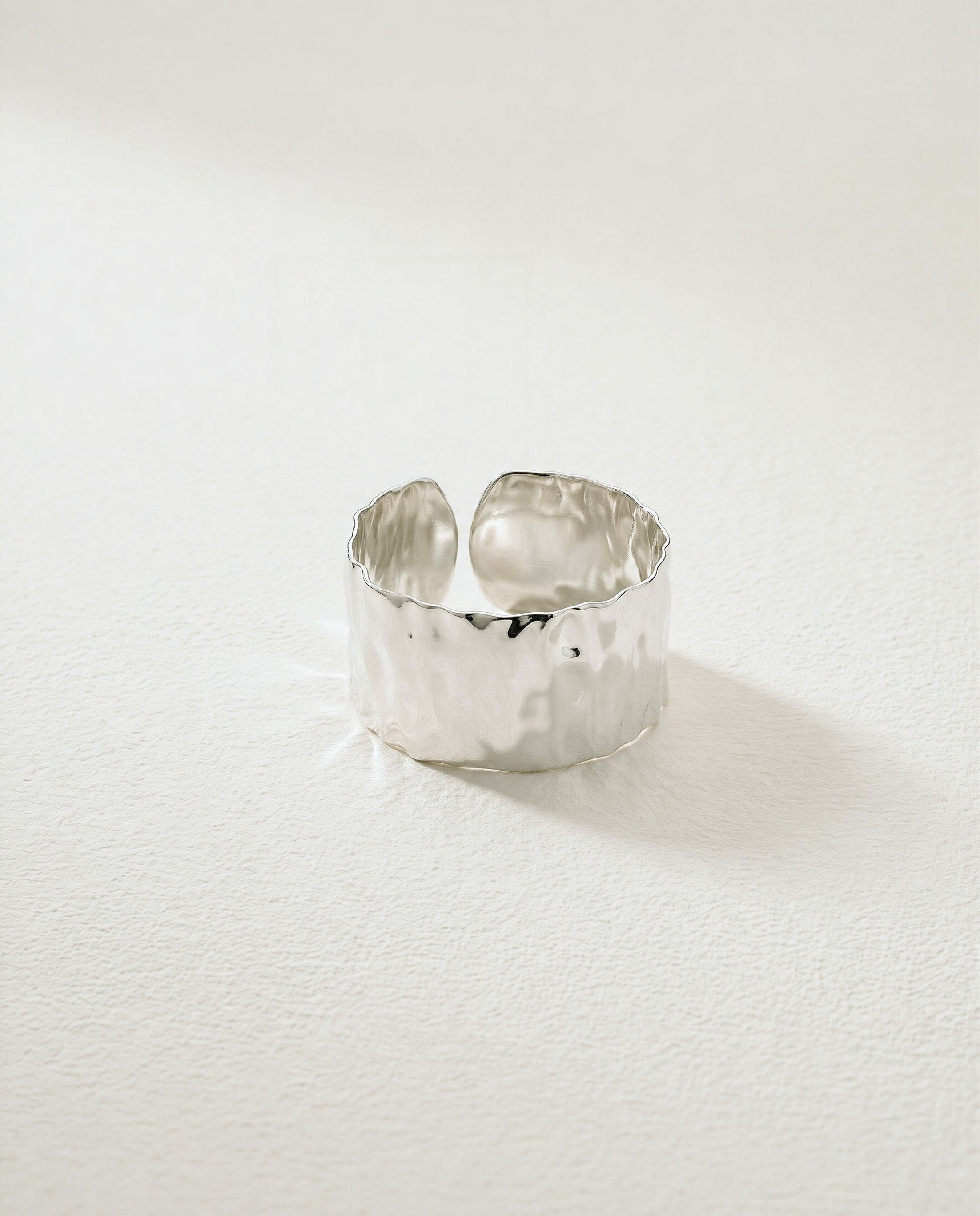 Wide Cuff Ring in silver with hammered surface. The model is Noem Bangle by Avelore.