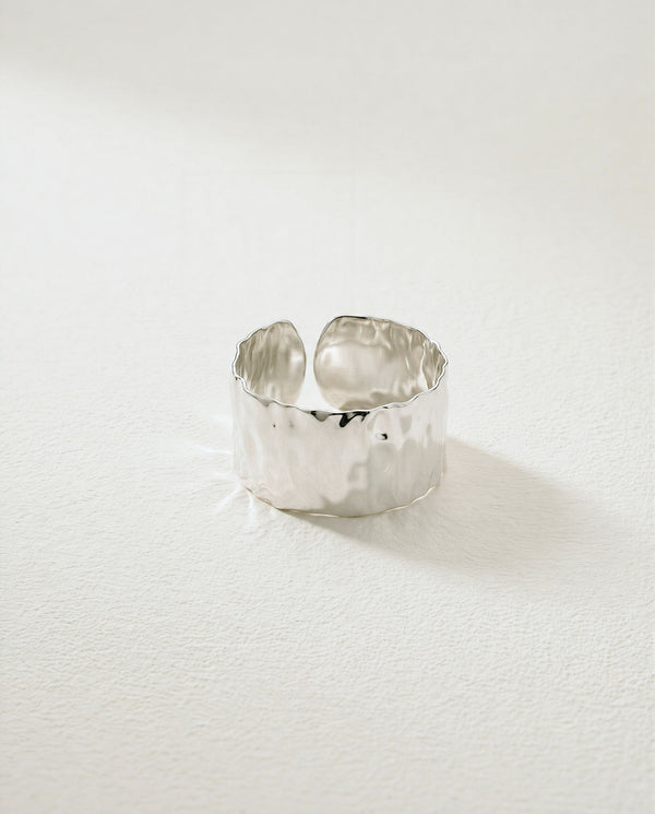 Wide Cuff Ring in silver with hammered surface. The model is Noem Bangle by Avelore.