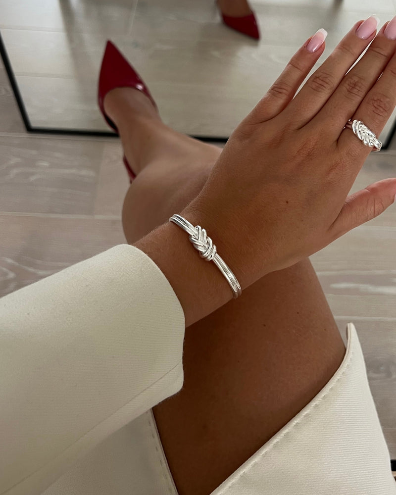 Silver bracelet with triple knot detail. The model is Naia bangle by Avelore Women's Bracelets
